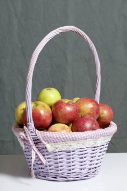Elma sonbahar hasat. Bir hasır asma sepetten elma. Gri bir arka plan üzerinde.