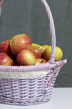 Elma sonbahar hasat. Bir hasır asma sepetten elma. Gri bir arka plan üzerinde.