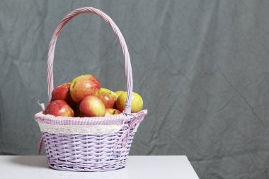 Elma sonbahar hasat. Bir hasır asma sepetten elma. Gri bir arka plan üzerinde.