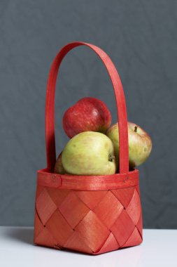 Elma sonbahar hasat. Bir hasır asma sepetten elma. Gri bir arka plan üzerinde.