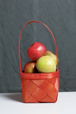 Elma sonbahar hasat. Bir hasır asma sepetten elma. Gri bir arka plan üzerinde.