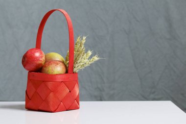 Elma sonbahar hasat. Bir hasır asma sepetten elma. Yakındaki spikelets tahıl. Gri bir arka plan üzerinde.