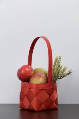 Elma sonbahar hasat. Bir hasır asma sepetten elma. Yakındaki spikelets tahıl. Beyaz bir arka plan üzerinde.