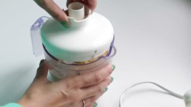 Kadın blender sebze ve diğer maddeler ile kapatır. İçeriğini karıştırmak başlar.