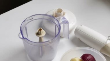 Bir blender sebze taşlama için geçerli. Konteyner yanında patates, kabak ve soğan vardır.