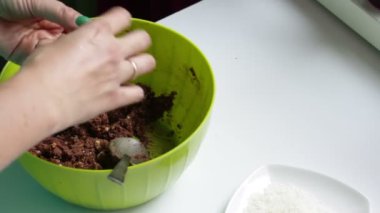 Bir kadın topları yağmurlama ile çikolatalı tatlılar yemek pişirmek için hazırlanan karışım, dışarı rulo.