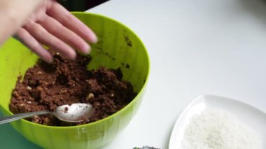 Bir kadın topları yağmurlama ile çikolatalı tatlılar yemek pişirmek için hazırlanan karışım, dışarı alır. Bundan sonra bir tabak üzerinde bitmiş topları o koyar.