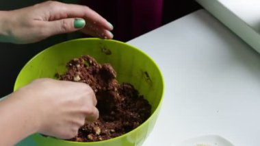 Bir kadın bir karışımı tatlılar için gelen topları alır. Kakao ve bisküvi çikolata tatlılar hazırlanması.