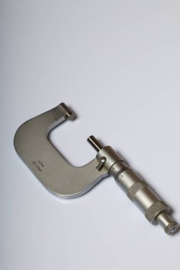 Dış ölçüler ve 25-50 mm ölçüm aralığı için mikrometre ile dairesel bir ölçek. Beyaz bir arka plan üzerinde.