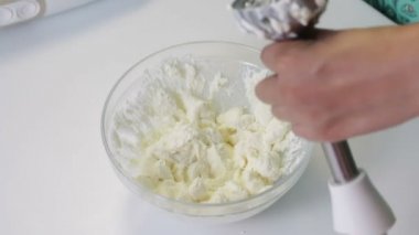 Araçlar ve sırlı curds yapmak için malzemeler. Onlar masada yerleştirilir. Kadın süzme peynir blender, şeker erimiş tereyağı ile karışık.
