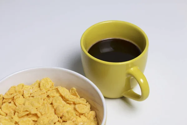 早餐很有用 玉米在容器里和一杯咖啡里贴着薄片 在白色背景上 — 图库照片