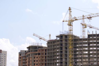 Kule vinç mavi gökyüzüne karşı bina. Binalar inşaat altında görülebilir.