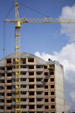 Kule vinç mavi gökyüzüne karşı bina. Binalar inşaat altında görülebilir.