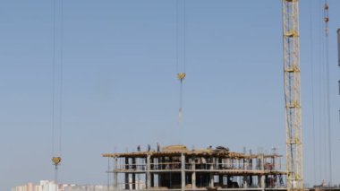 Beton inşaat yapı çerçeve yaptı. İnşaat işçileri hareket ediyor, Kule Vinç kanca sallamanın.