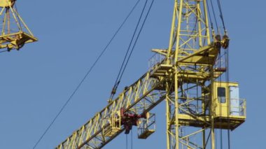 Kule vinç binanın oklar. Kayanın üzerinde mavi gökyüzü.