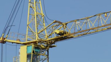 Kule vinç binanın oklar. Mavi gökyüzü devam et. Dikey kablo kamera.