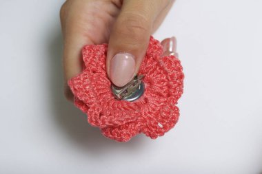 Bir kadın bir metal saç tokası bir çiçek şeklinde örme bir broş için tutkallar.