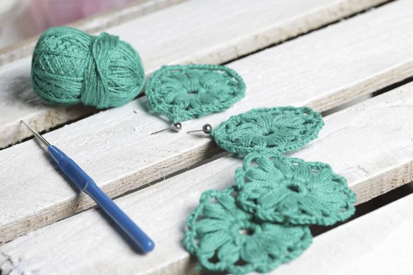 Takı kadınlar için tığ işi. Bir girişimci tarafından örme küpe. Konu örgü, demir çubuklar ve bitmiş ürünler için.