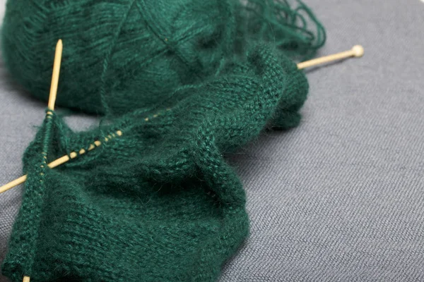 木編みのニット 暗い緑の糸と未完成のニットで木製の編み針のボール — ストック写真