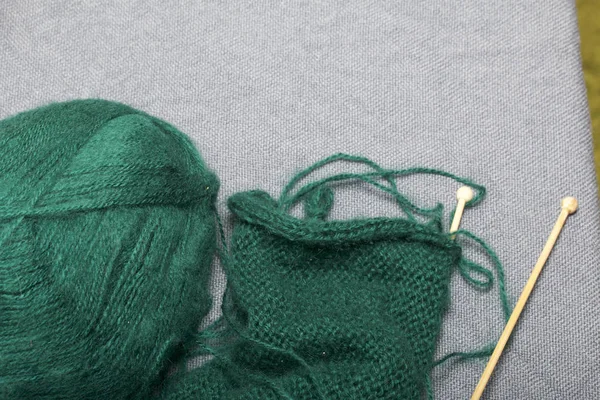 木編みのニット 暗い緑の糸と未完成のニットで木製の編み針のボール — ストック写真