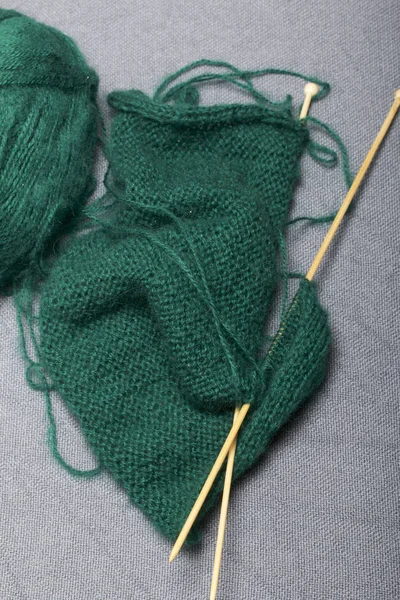 针织木制针织 一根深绿色的线球和木制针织针在未完成的针织 — 图库照片