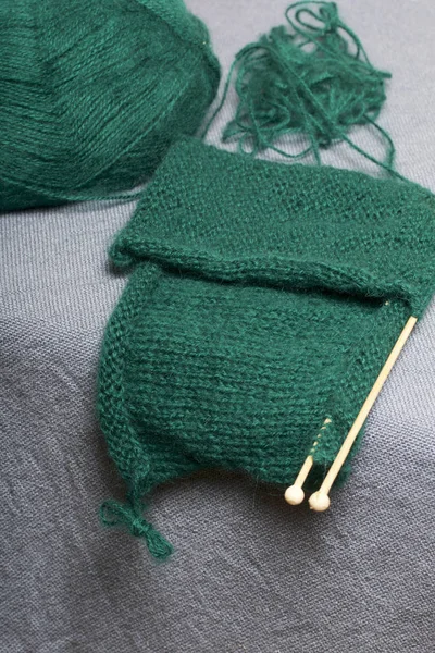 针织木制针织 一根深绿色的线球和木制针织针在未完成的针织 — 图库照片