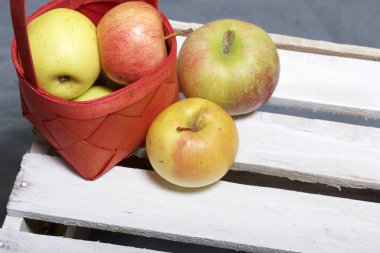 Hasır sepet içinde olgunlaşmış aromatik elma. Panoları dışarı çaldı bir ahşap kutu üzerinde yer alan.
