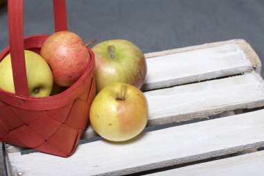 Hasır sepet içinde olgunlaşmış aromatik elma. Panoları dışarı çaldı bir ahşap kutu üzerinde yer alan.