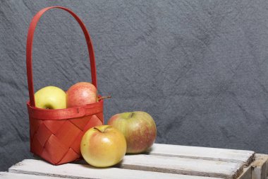 Hasır sepet içinde olgunlaşmış aromatik elma. Panoları dışarı çaldı bir ahşap kutu üzerinde yer alan.