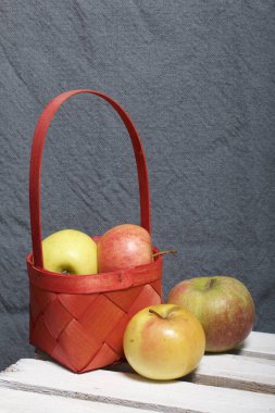 Hasır sepet içinde olgunlaşmış aromatik elma. Panoları dışarı çaldı bir ahşap kutu üzerinde yer alan.