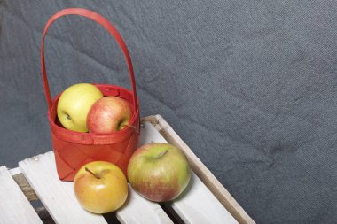 Hasır sepet içinde olgunlaşmış aromatik elma. Panoları dışarı çaldı bir ahşap kutu üzerinde yer alan.