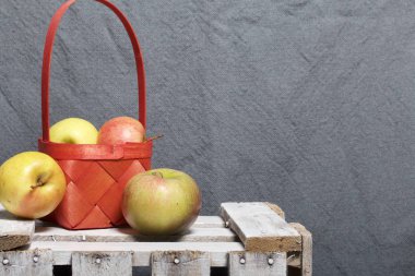 Hasır sepet içinde olgunlaşmış aromatik elma. Panoları dışarı çaldı bir ahşap kutu üzerinde yer alan.