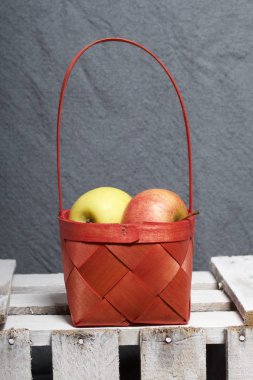 Hasır sepet içinde olgunlaşmış aromatik elma. Panoları dışarı çaldı bir ahşap kutu üzerinde yer alan.