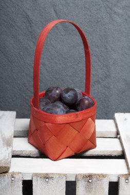 Hasır sepet içinde olgunlaşmış kokulu Erik. Panoları dışarı çaldı bir ahşap kutu üzerinde yer alan.