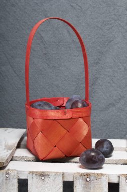 Hasır sepet içinde olgunlaşmış kokulu Erik. Panoları dışarı çaldı bir ahşap kutu üzerinde yer alan.