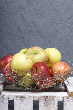 Olgun aromatik elma çelik sepet içinde. Panoları dışarı çaldı bir ahşap kutu üzerinde yer alan.