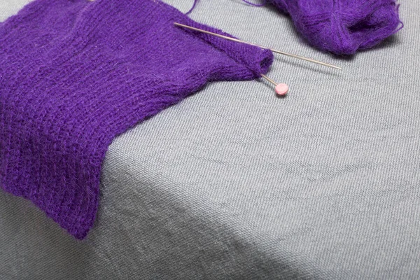 针织用钢针织针 在未完成的针织中的紫色螺纹和钢针织针球 — 图库照片