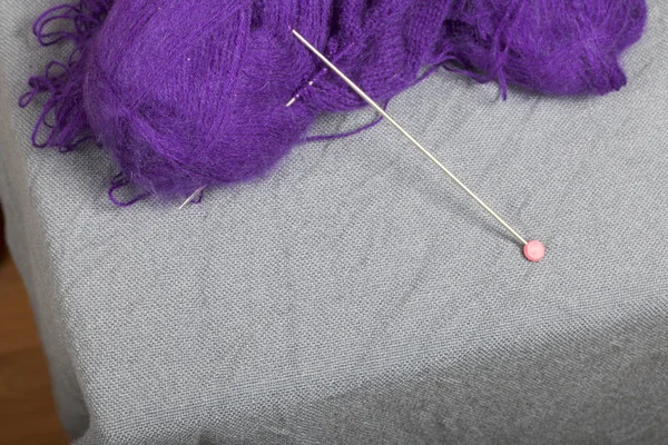 针织用钢针织针 在未完成的针织中的紫色螺纹和钢针织针球 — 图库照片