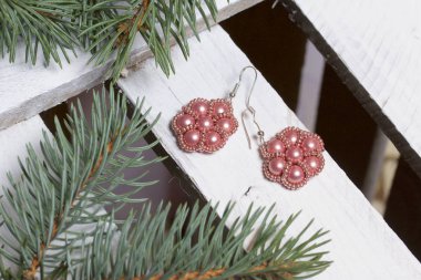 Mavi Ladin dallarda panoları, beyaz boyalı bir ahşap kutu. Yakında orada küpe ve kavanoz boncuklar ile.