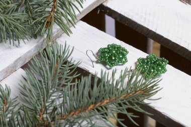 Mavi Ladin dallarda panoları, beyaz boyalı bir ahşap kutu. Yakında orada küpe ve kavanoz boncuklar ile.