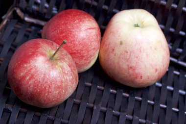 Bir hasır sepet Vines arka plan üzerinde olgunlaşmış aromatik elma.