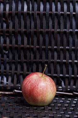 Bir hasır sepet Vines arka plan üzerinde olgunlaşmış aromatik elma.