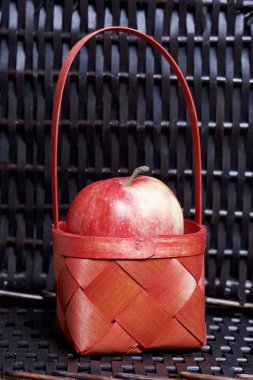 Olgun aromatik elma kırmızı hasır sepetin içinde. Hasır bir hasır sepet arka planı.