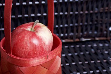 Olgun aromatik elma kırmızı hasır sepetin içinde. Hasır bir hasır sepet arka planı.