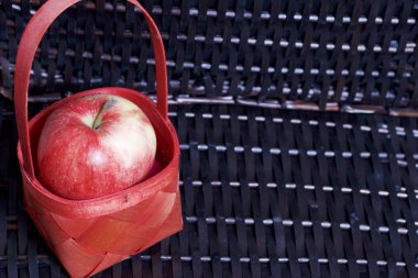 Olgun aromatik elma kırmızı hasır sepetin içinde. Hasır bir hasır sepet arka planı.