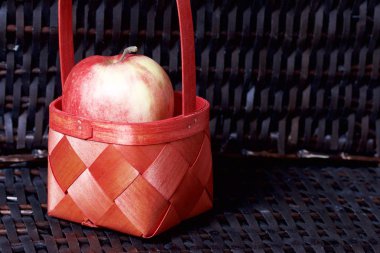 Olgun aromatik elma kırmızı hasır sepetin içinde. Hasır bir hasır sepet arka planı.