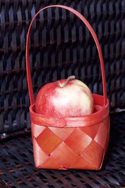 Olgun aromatik elma kırmızı hasır sepetin içinde. Hasır bir hasır sepet arka planı.