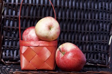 Olgun aromatik elma kırmızı hasır sepetin içinde. Hasır bir hasır sepet arka planı.