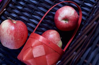 Olgun aromatik elma kırmızı hasır sepetin içinde. Hasır bir hasır sepet arka planı.