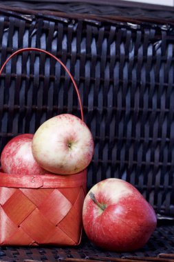Olgun aromatik elma kırmızı hasır sepetin içinde. Hasır bir hasır sepet arka planı.